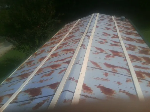 Rusted metal roof panels with new wood purlins before replacement — Storm Damage Roof Repair in Cosmopolis by Roofing Brothers