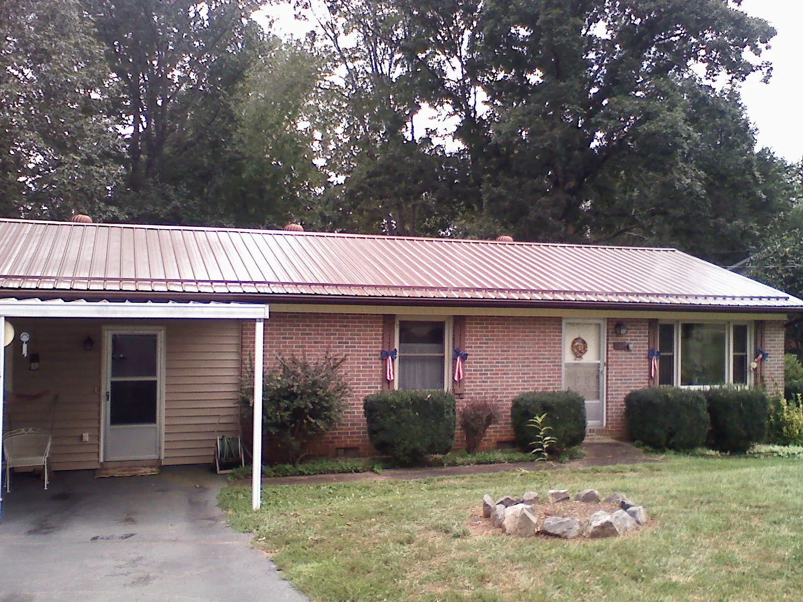 Bronze metal roof and carport on a brick ranch home — Roof Repair work by our crew in Cosmopolis